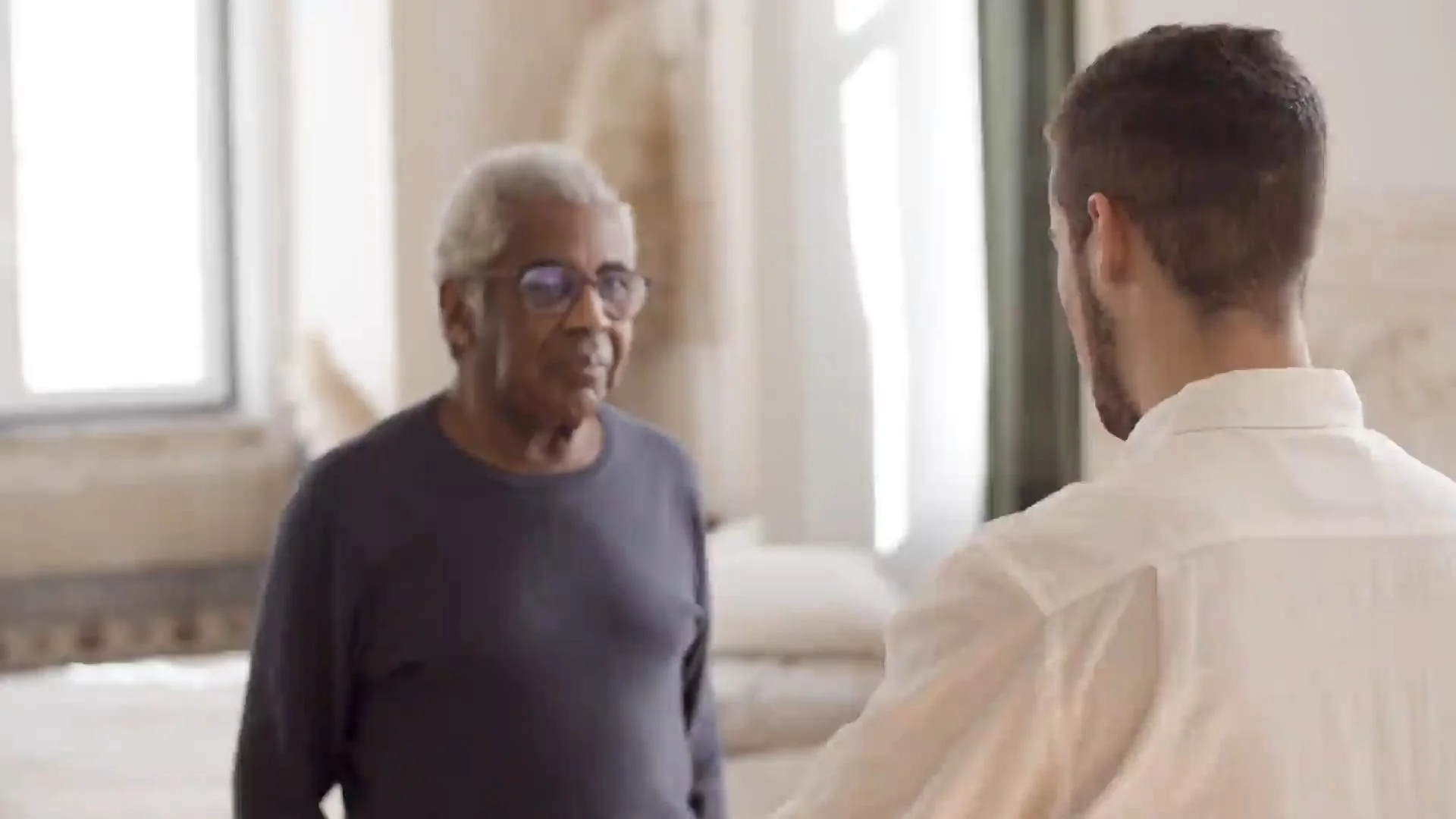 Older man talking with younger man indoors